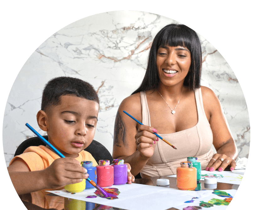 Jeybriel painting at a table with his mom