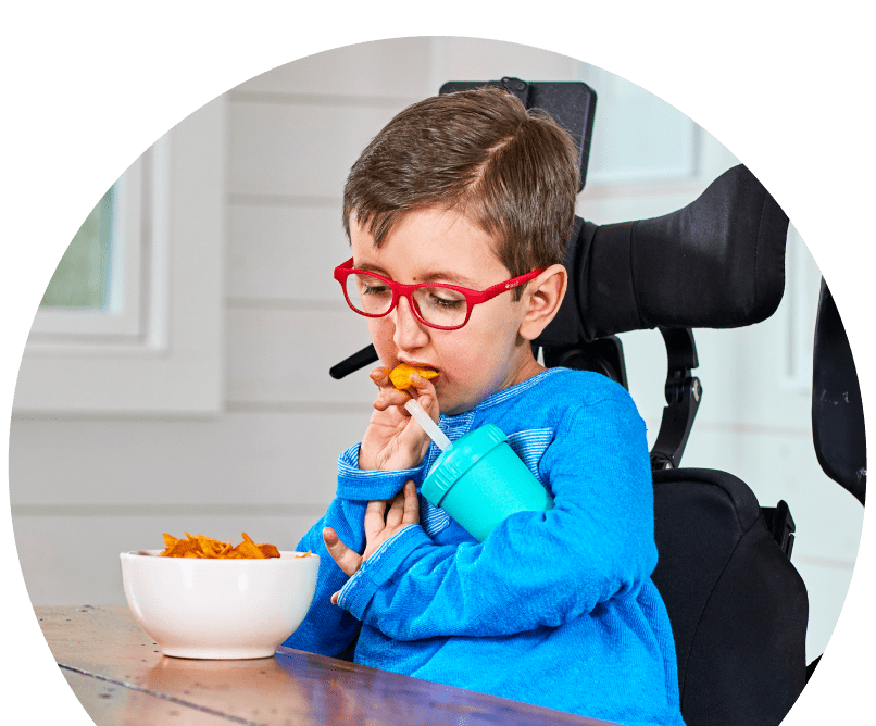Bear seated at a table eating a snack from a bowl